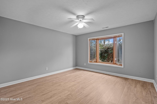 spare room with a textured ceiling, light hardwood / wood-style flooring, and ceiling fan