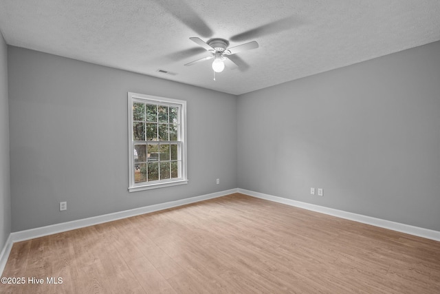 unfurnished room featuring ceiling fan, light wood-type flooring, and a textured ceiling