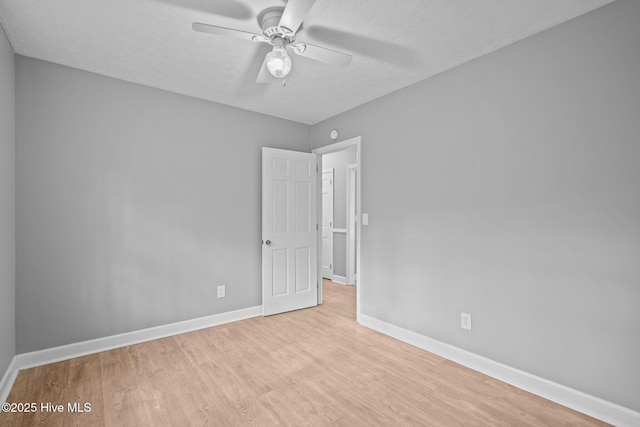 unfurnished room featuring a textured ceiling, light wood-type flooring, and ceiling fan