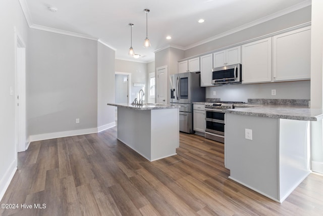 kitchen featuring stainless steel appliances, a kitchen island with sink, decorative light fixtures, hardwood / wood-style flooring, and white cabinets