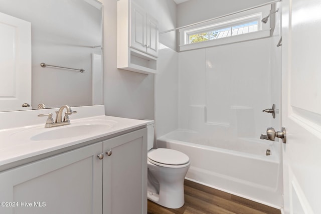 full bathroom featuring hardwood / wood-style flooring, vanity,  shower combination, and toilet