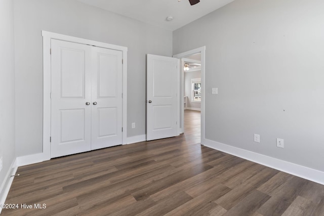 unfurnished bedroom with ceiling fan, dark wood-type flooring, and a closet