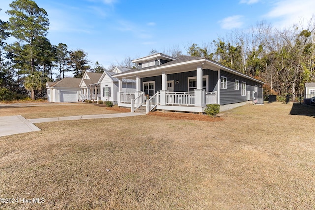 view of front of property featuring a porch, a garage, and a front yard