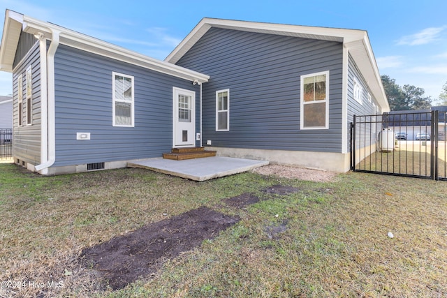 back of house with a lawn and a patio area