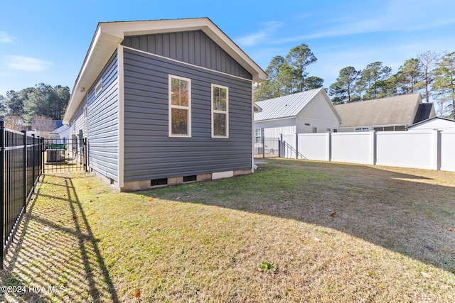 view of side of property featuring a lawn and central AC unit