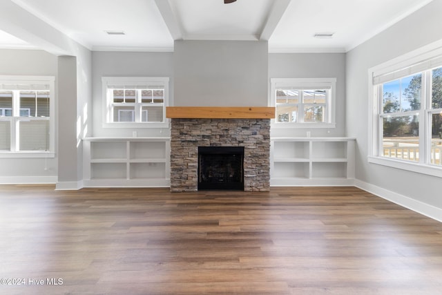 unfurnished living room featuring a stone fireplace, crown molding, and wood-type flooring