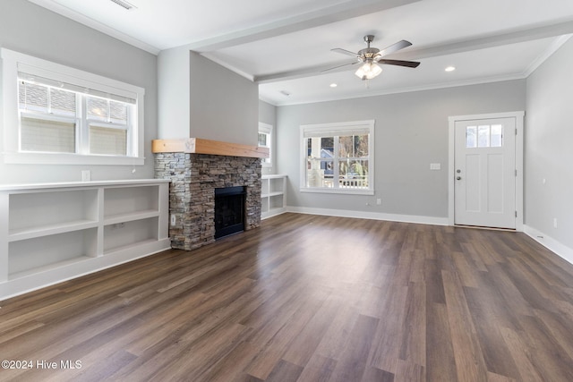 unfurnished living room with ornamental molding, a stone fireplace, ceiling fan, and dark wood-type flooring