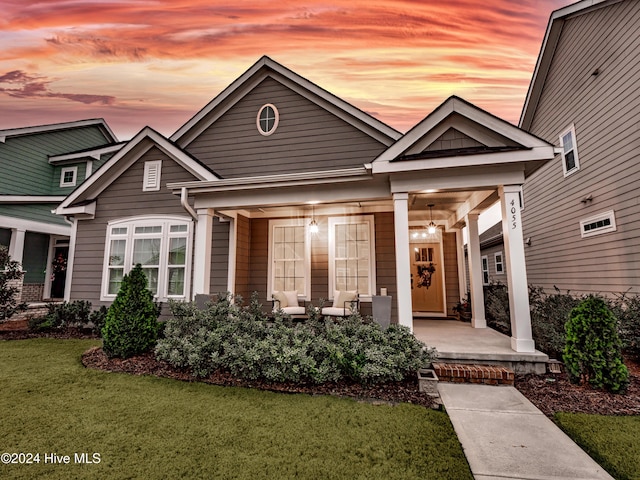 craftsman-style house featuring a yard and covered porch