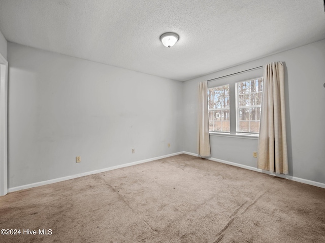 carpeted spare room featuring a textured ceiling