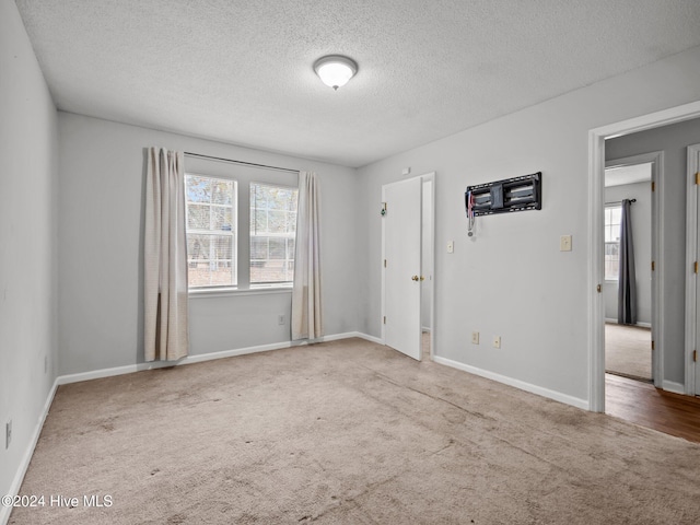 empty room featuring carpet flooring and a textured ceiling