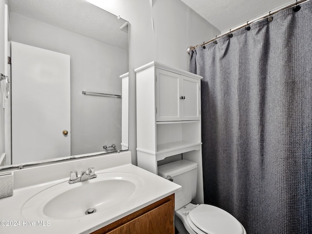 bathroom featuring vanity, a textured ceiling, and toilet