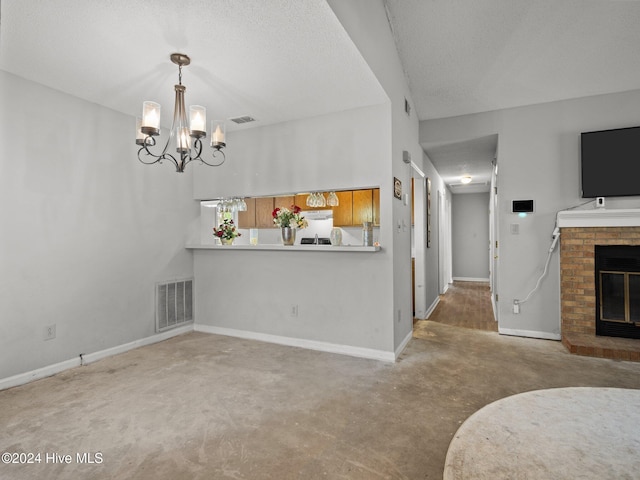 dining space featuring carpet, a textured ceiling, an inviting chandelier, and a brick fireplace