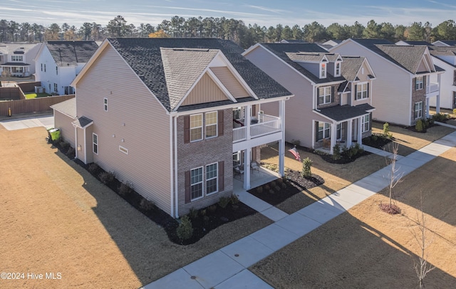 view of front of property with a balcony and a front yard