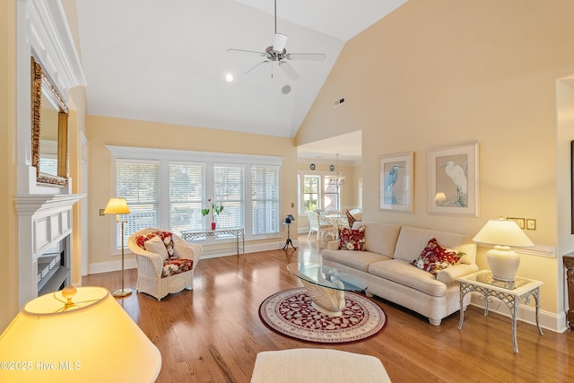 living room with hardwood / wood-style flooring, ceiling fan, and high vaulted ceiling