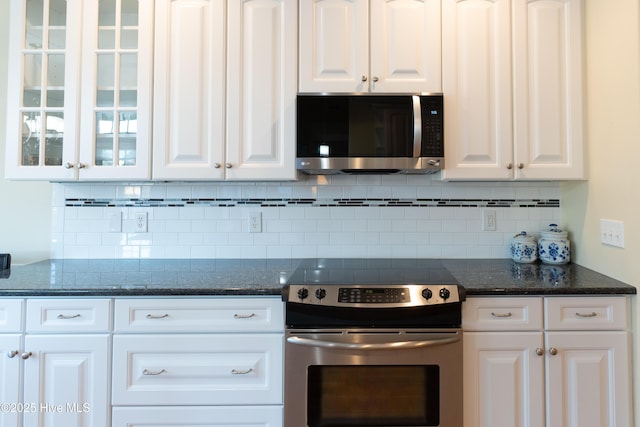 kitchen featuring decorative backsplash, white cabinetry, and stainless steel appliances