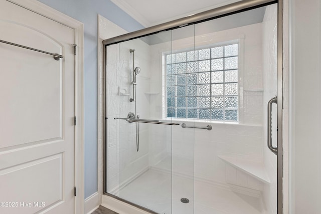 bathroom featuring crown molding and a shower with shower door