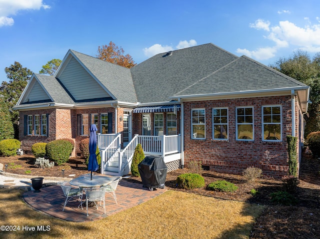 back of property with a yard and a patio