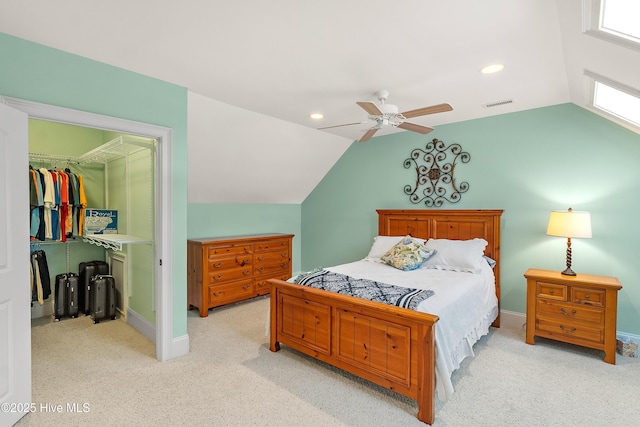 bedroom featuring light carpet, vaulted ceiling, ceiling fan, a spacious closet, and a closet