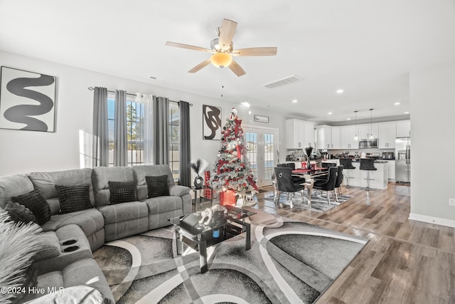 living room featuring a wealth of natural light, light hardwood / wood-style flooring, and ceiling fan