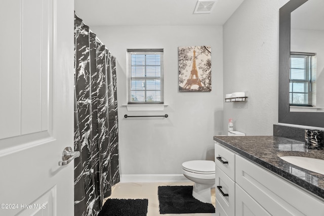 bathroom featuring tile patterned flooring, vanity, and toilet