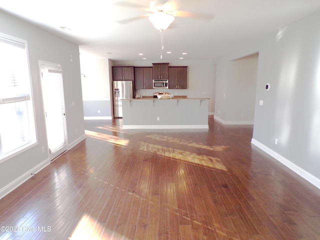 unfurnished living room featuring ceiling fan and dark hardwood / wood-style flooring