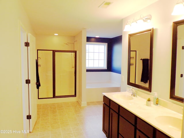 bathroom with vanity and shower with separate bathtub