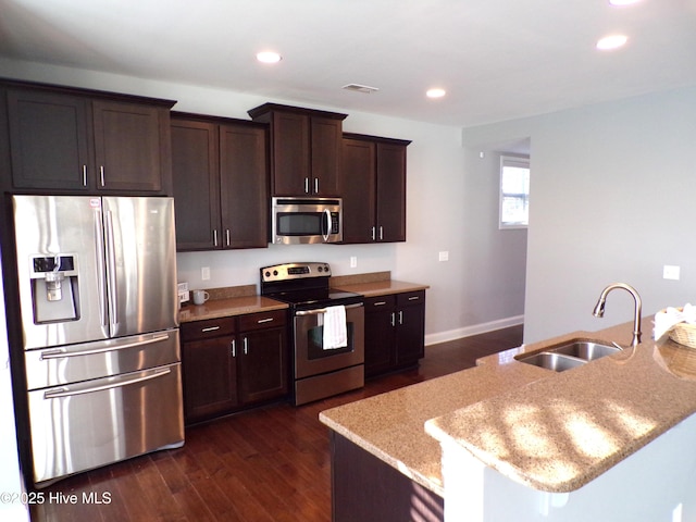 kitchen with dark brown cabinetry, sink, stainless steel appliances, and dark hardwood / wood-style flooring