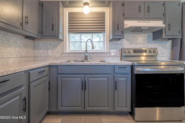 kitchen with tasteful backsplash, sink, gray cabinetry, and electric range