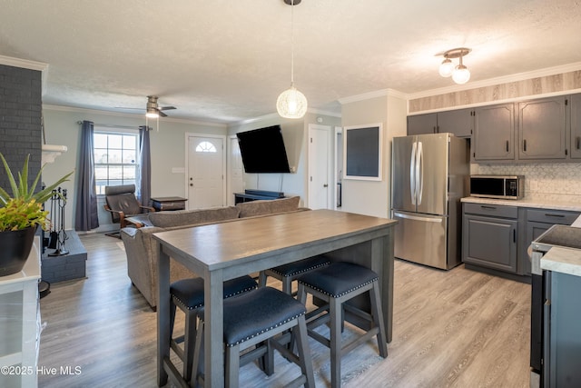 kitchen with appliances with stainless steel finishes, decorative light fixtures, gray cabinets, and a textured ceiling