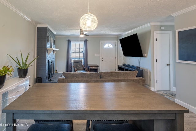 unfurnished dining area with crown molding, a fireplace, light hardwood / wood-style floors, and a textured ceiling