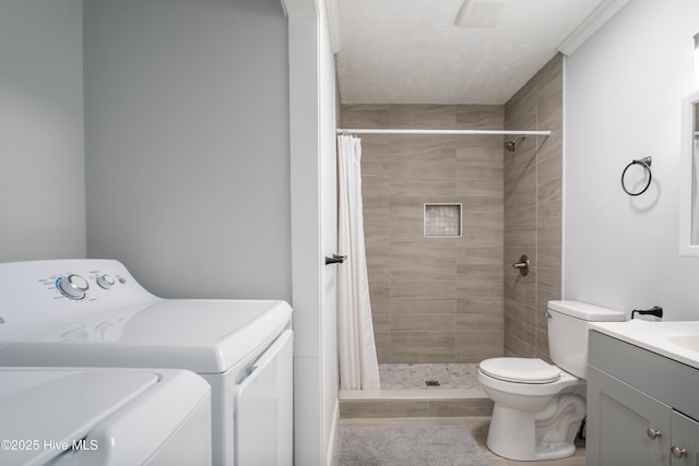 bathroom with a shower with curtain, washing machine and clothes dryer, vanity, and toilet