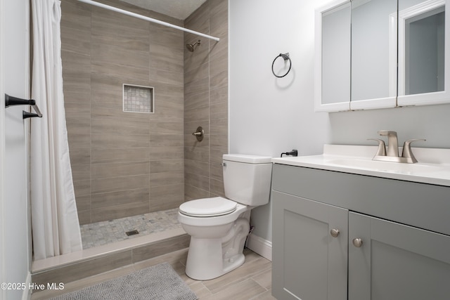 bathroom with vanity, walk in shower, and toilet