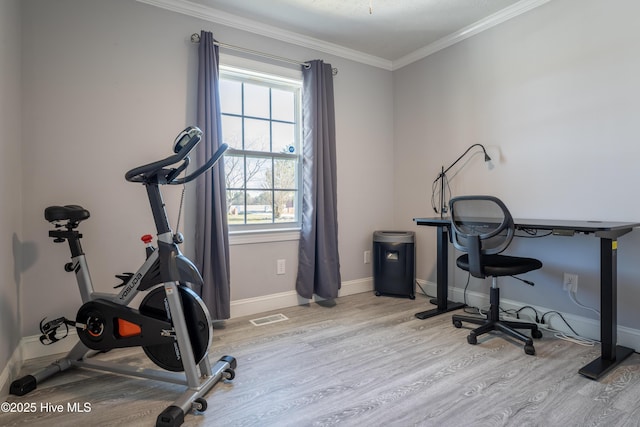 workout room featuring ornamental molding, plenty of natural light, and light hardwood / wood-style floors