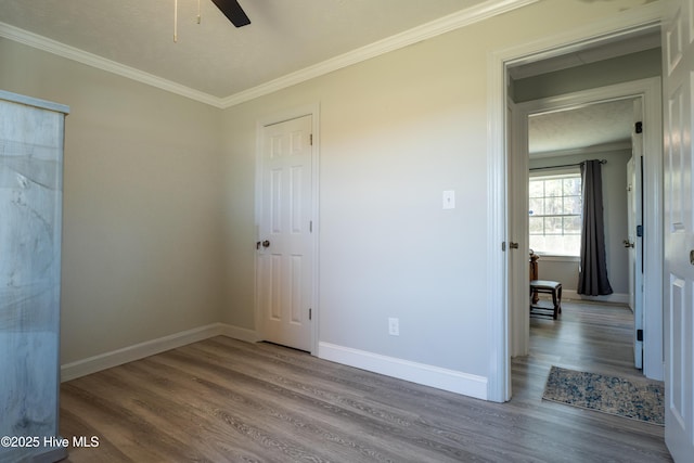 unfurnished bedroom with ceiling fan, ornamental molding, and hardwood / wood-style floors