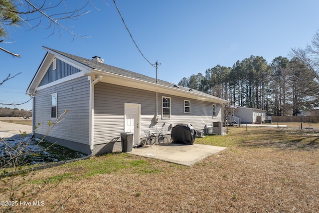 back of property with a yard and a patio