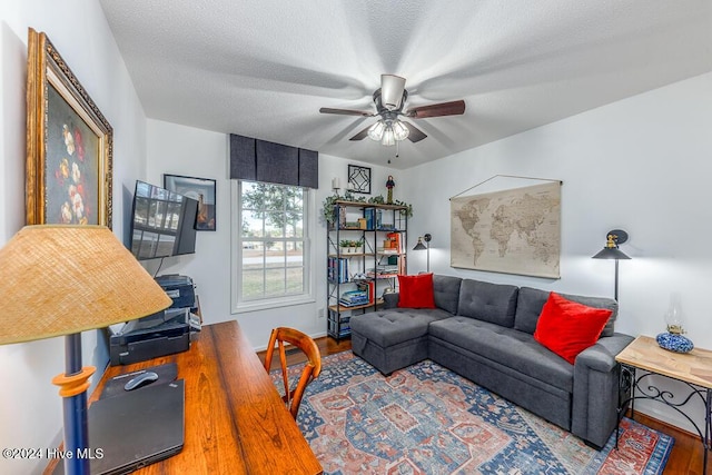 living room with hardwood / wood-style floors, a textured ceiling, and ceiling fan