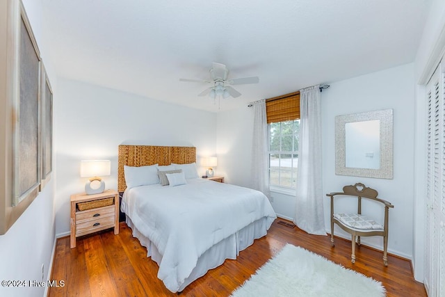 bedroom with ceiling fan, wood-type flooring, and a closet