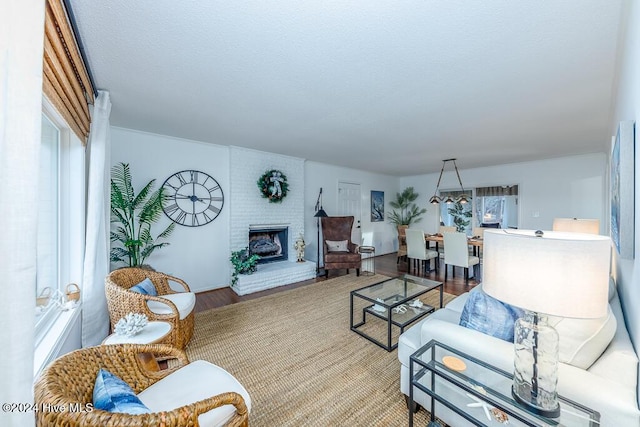 living room with wood-type flooring and a brick fireplace