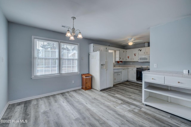 kitchen featuring ceiling fan with notable chandelier, white appliances, tile counters, white cabinetry, and hanging light fixtures