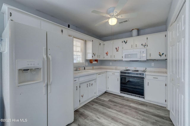 kitchen with white cabinets, white appliances, and sink