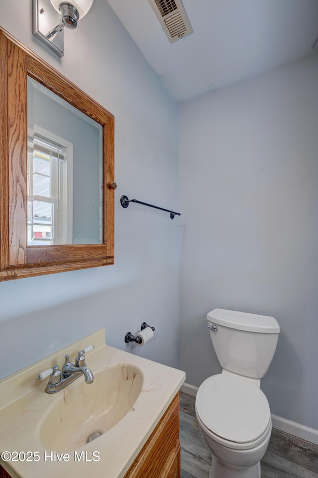 bathroom with hardwood / wood-style floors, vanity, and toilet