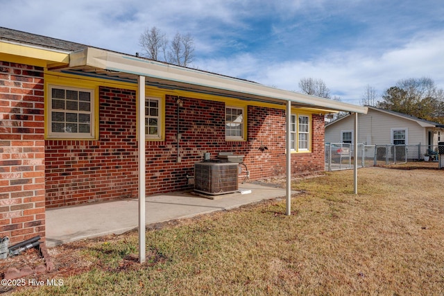 rear view of house with a lawn and cooling unit