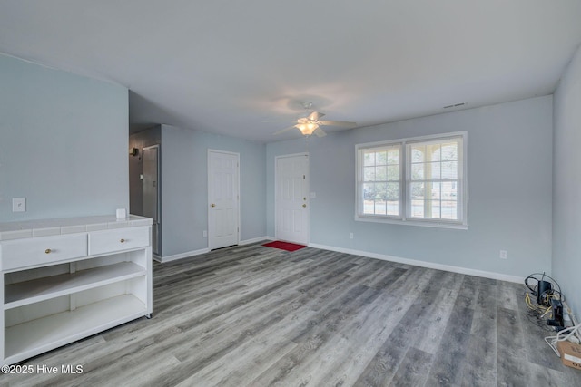 unfurnished living room featuring ceiling fan and light hardwood / wood-style flooring