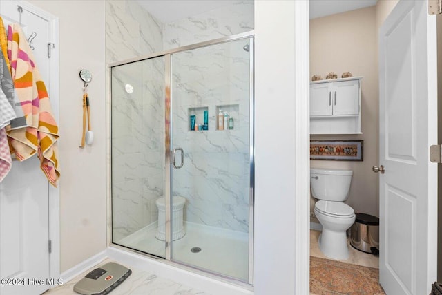 bathroom with a shower with shower door and toilet