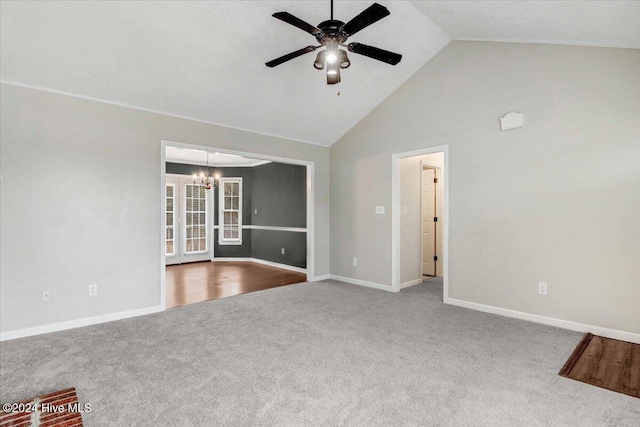 unfurnished living room with ceiling fan with notable chandelier, light carpet, and high vaulted ceiling