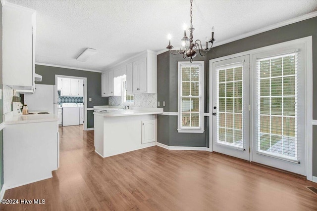 kitchen with white cabinetry, a healthy amount of sunlight, decorative light fixtures, and light hardwood / wood-style floors