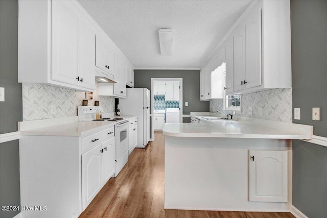 kitchen featuring kitchen peninsula, white appliances, sink, light hardwood / wood-style flooring, and white cabinetry