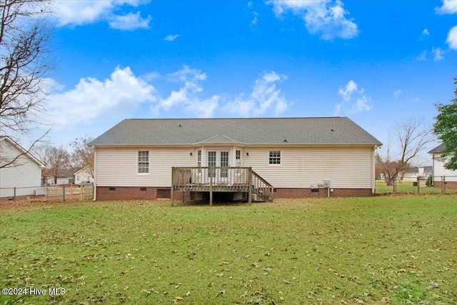 rear view of house featuring a lawn and a wooden deck