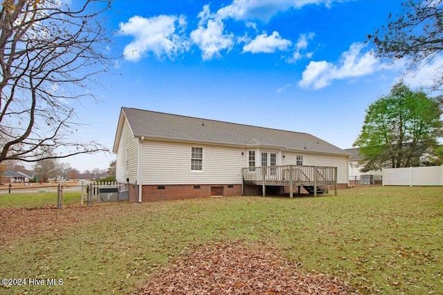 back of property featuring a lawn and a deck