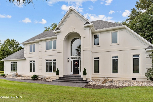 rear view of property featuring a lawn